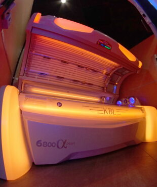 A tanning bed with lights on in the room.