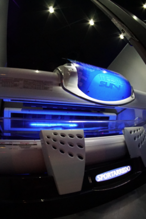 A tanning bed with blue lights in the room.