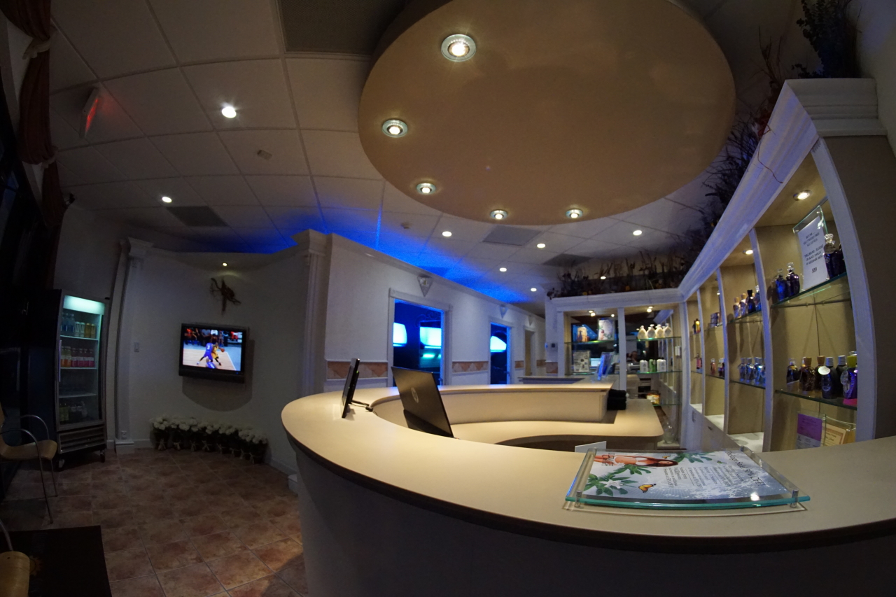 A reception area with a curved counter and television.