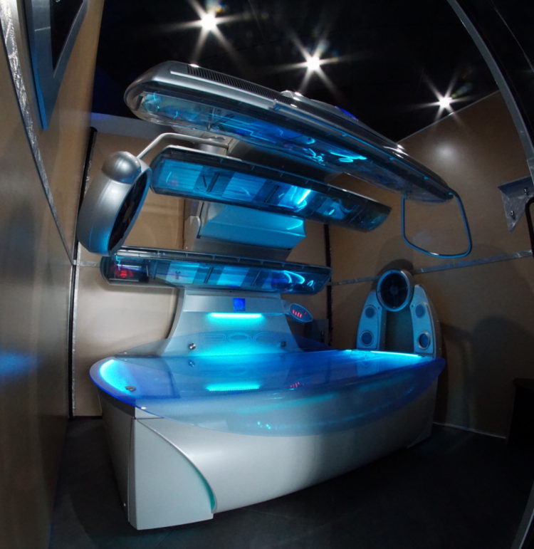 A futuristic looking room with lights on the ceiling.