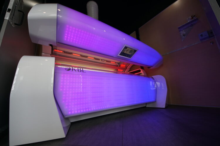 A tanning bed with purple lights on it.