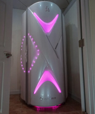 A white and pink light up machine in the corner of room.