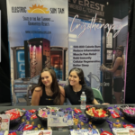 Two women sitting at a table with some candy.