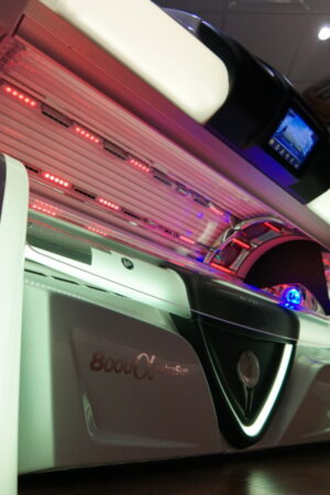 A white tanning bed with red lights on it.