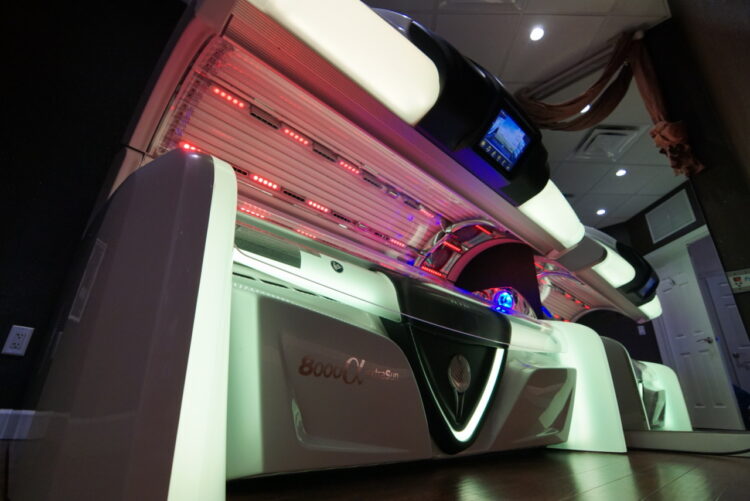 A white tanning bed with red lights on it.