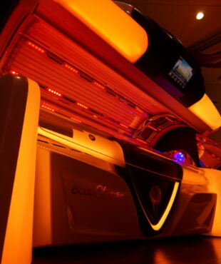 A tanning bed with lights on the side of it.