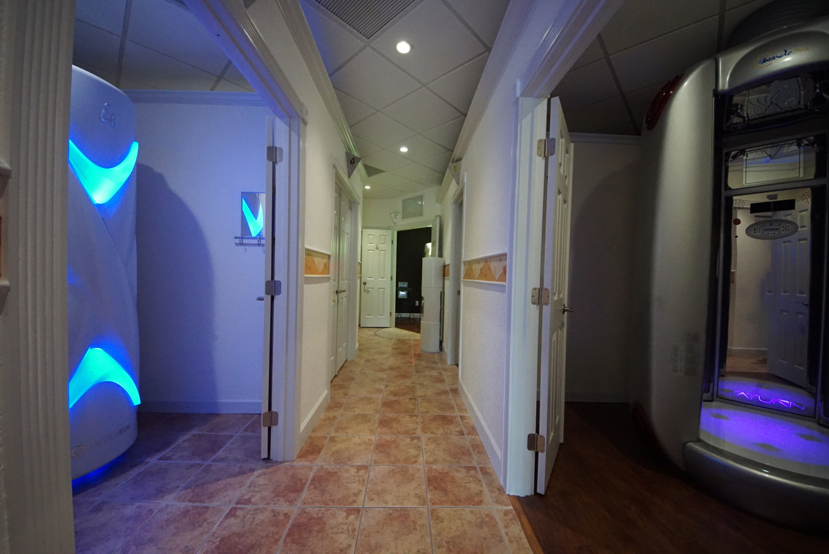 A hallway with two doors and tiled floors